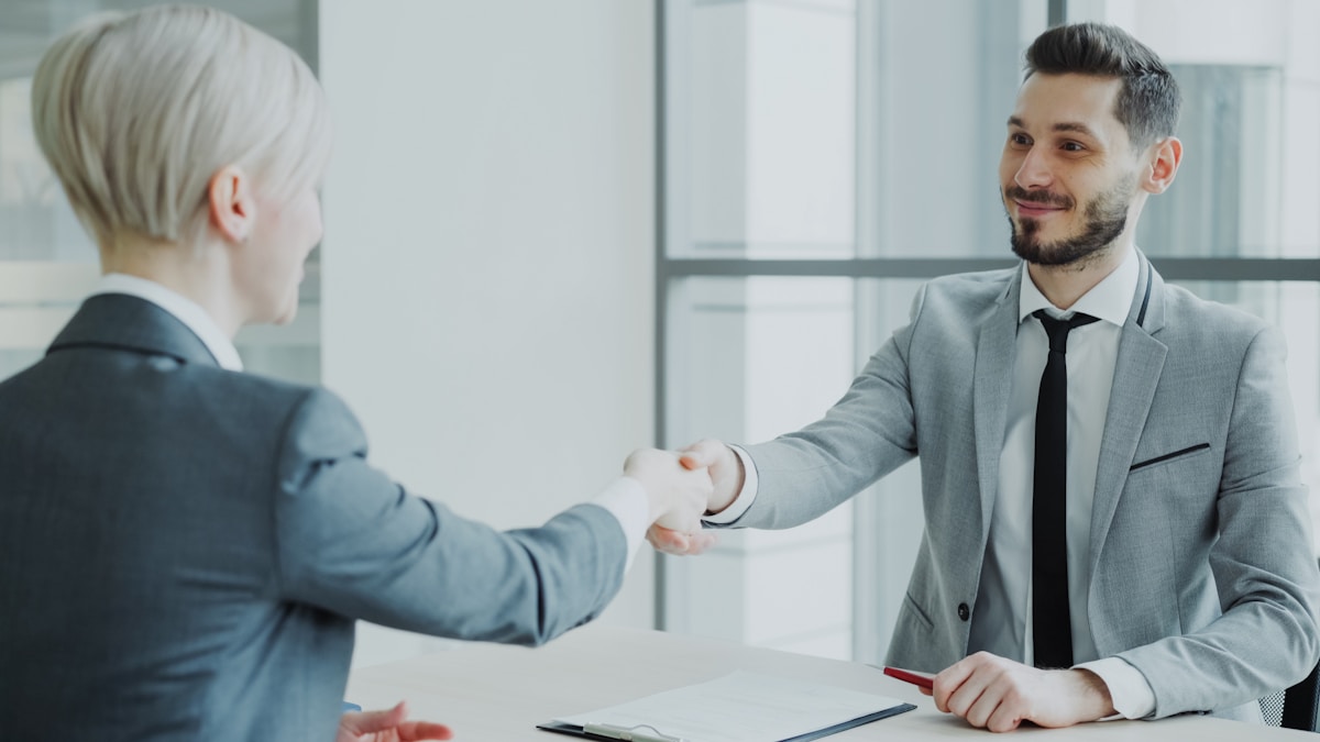 Two people shaking hands over an agreement