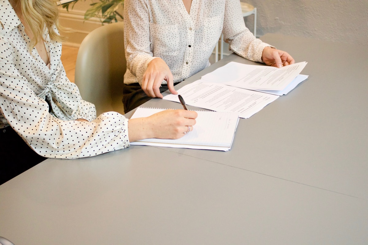 Two people completing and signing an agreement at a desk